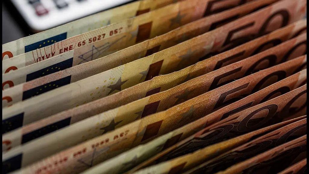 Vista macro de billetes de euro formando un colchón protector con calculadora financiera desenfocada al fondo